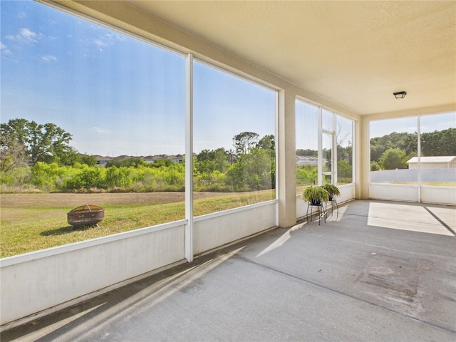 sunroom / solarium with a fire pit and a healthy amount of sunlight