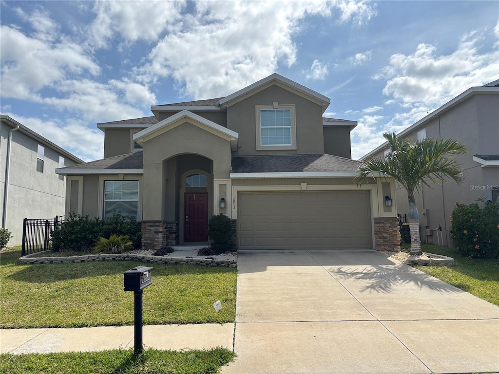 view of front of house featuring stucco siding, fence, a front lawn, concrete driveway, and an attached garage