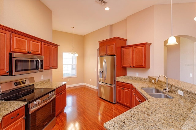 kitchen with light wood-style flooring, arched walkways, a sink, visible vents, and appliances with stainless steel finishes