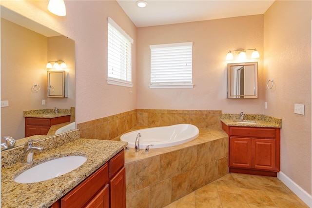 bathroom with a garden tub, two vanities, and a sink