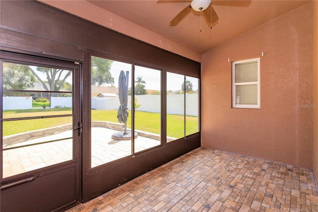 unfurnished sunroom featuring ceiling fan and a healthy amount of sunlight
