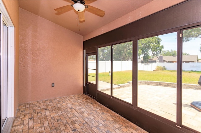 unfurnished sunroom featuring ceiling fan
