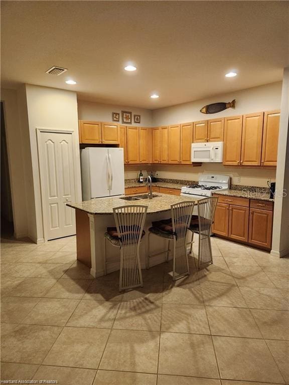 1375 Backspin Dr, Englewood, FL 34223 - kitchen featuring a breakfast bar, white appliances, a sink, and recessed lighting