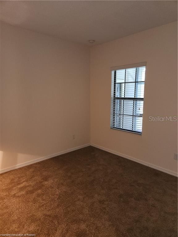 1375 Backspin Dr, Englewood, FL 34223 - spare room featuring baseboards and dark colored carpet