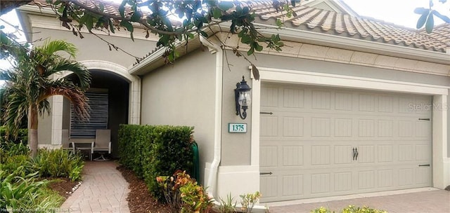 1375 Backspin Dr, Englewood, FL 34223 - view of side of property with stucco siding, an attached garage, and driveway
