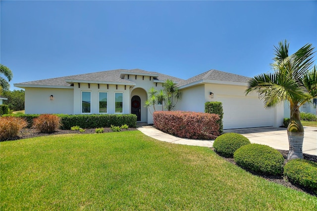 mediterranean / spanish house with roof with shingles, a garage, a front lawn, concrete driveway, and stucco siding
