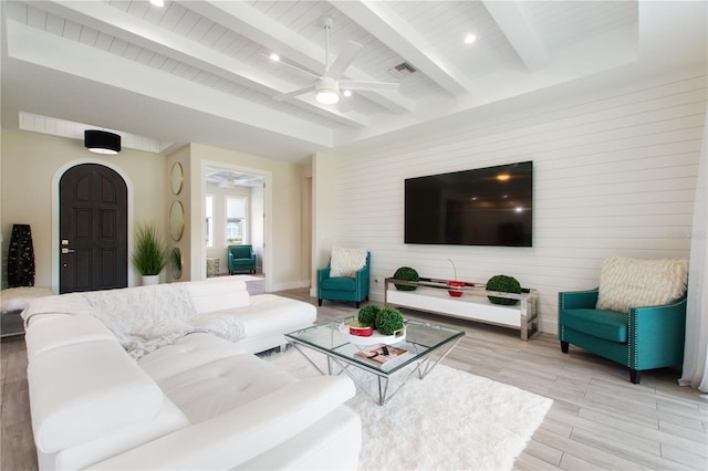 living area with ceiling fan, visible vents, beam ceiling, wooden walls, and light wood-style flooring