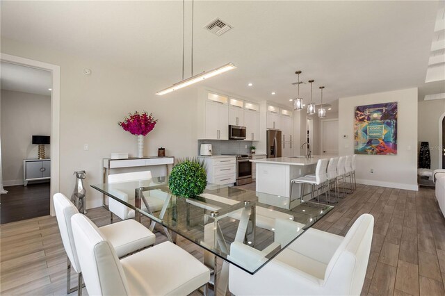 dining space featuring recessed lighting, baseboards, light wood finished floors, and visible vents
