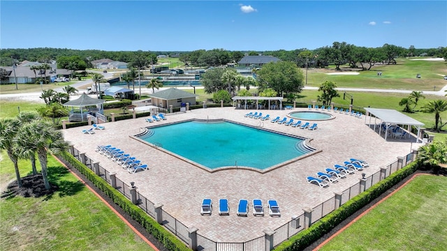 community pool with fence and a patio
