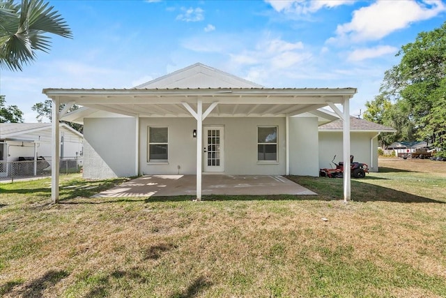 back of property with a patio, stucco siding, fence, and a yard