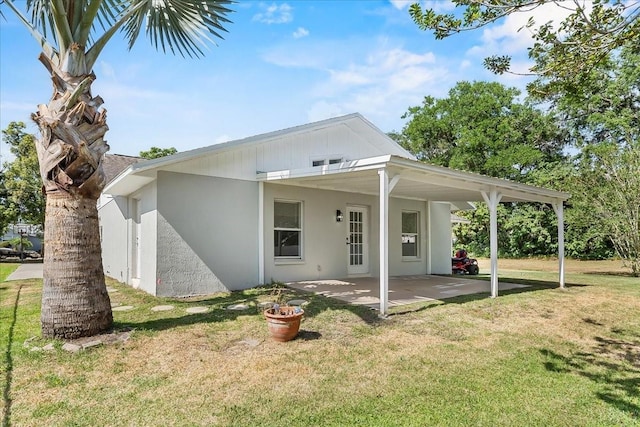 view of front of property with a patio, a front yard, and stucco siding