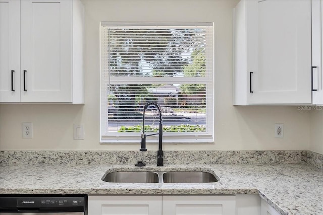 kitchen with white cabinetry, a wealth of natural light, a sink, and dishwashing machine