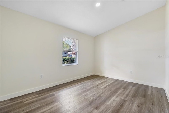 unfurnished room featuring baseboards, recessed lighting, and wood finished floors