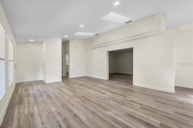 interior space featuring light wood-style floors, recessed lighting, baseboards, a skylight, and visible vents