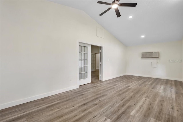 unfurnished room featuring a ceiling fan, baseboards, a wall mounted AC, and wood finished floors