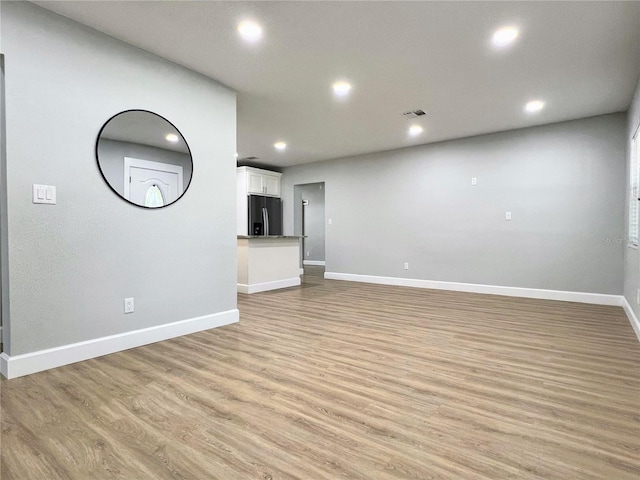 unfurnished living room with baseboards, recessed lighting, visible vents, and light wood finished floors