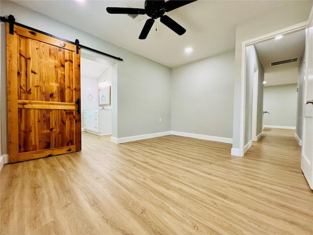interior space with recessed lighting, light wood-style flooring, a barn door, visible vents, and a ceiling fan