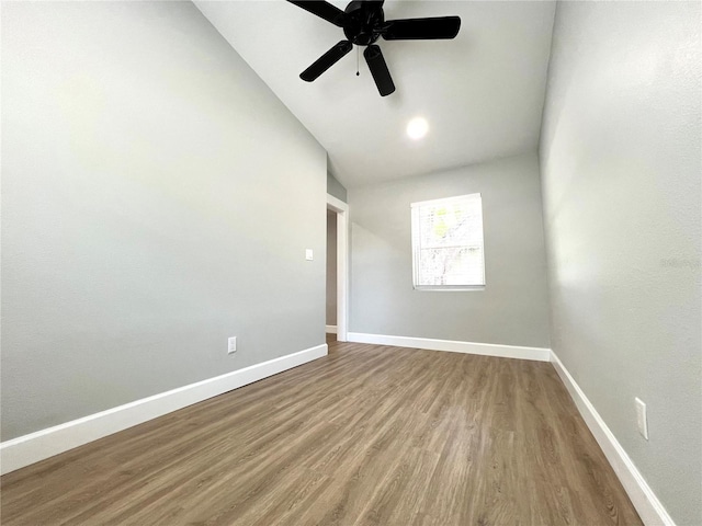 unfurnished room with wood finished floors, a ceiling fan, high vaulted ceiling, and baseboards