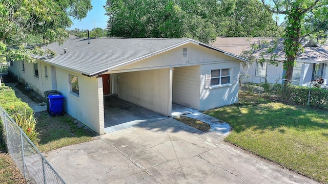 single story home with fence, a shingled roof, a front yard, a carport, and driveway