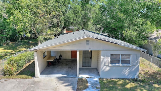 bungalow-style home featuring fence, an attached carport, and driveway