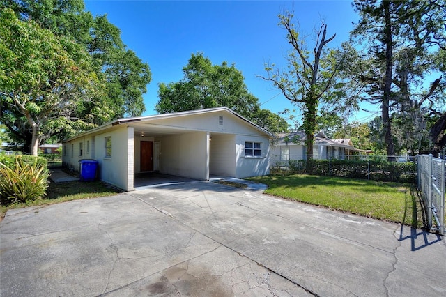 exterior space featuring concrete driveway, fence, and a carport