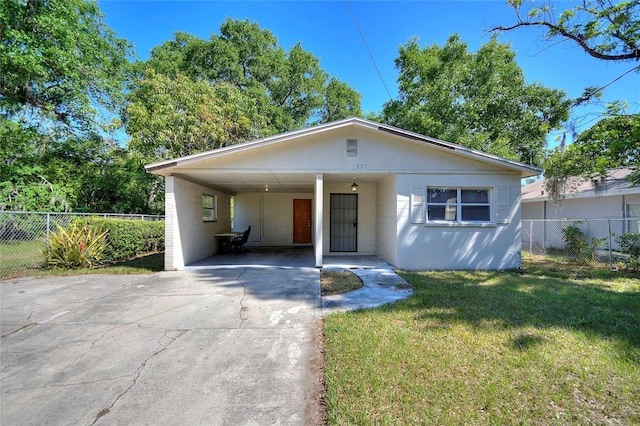 bungalow-style home featuring a carport, a front lawn, fence, and concrete driveway