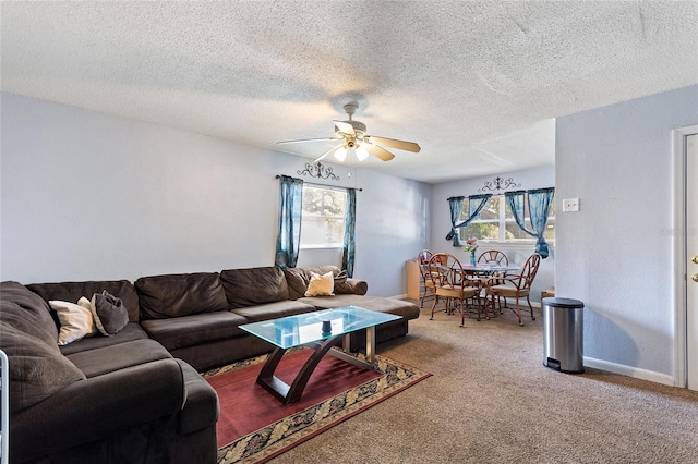 carpeted living room featuring baseboards, a textured ceiling, and ceiling fan