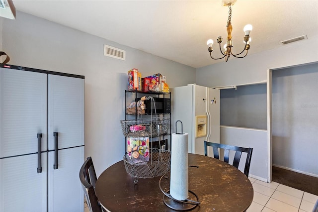 tiled dining room with visible vents and an inviting chandelier