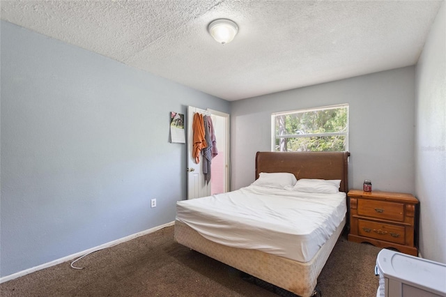 carpeted bedroom with baseboards and a textured ceiling