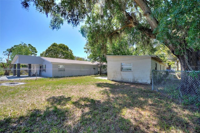 view of yard featuring fence and a carport