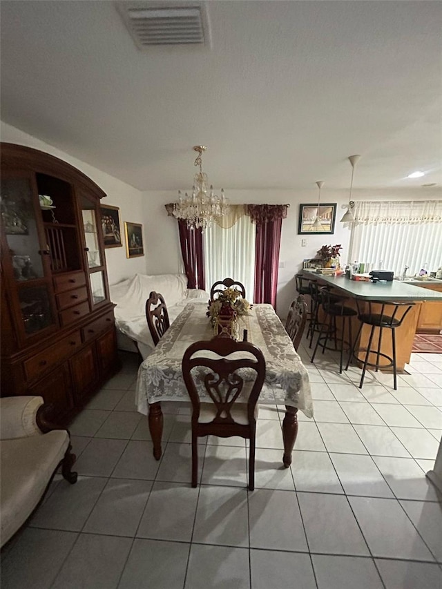 dining space with light tile patterned floors, visible vents, and a chandelier