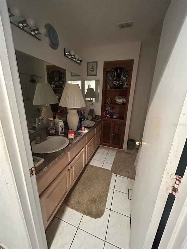 full bathroom with tile patterned flooring, a sink, double vanity, and visible vents