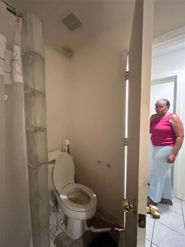 bathroom with visible vents, toilet, a shower with curtain, and tile patterned flooring