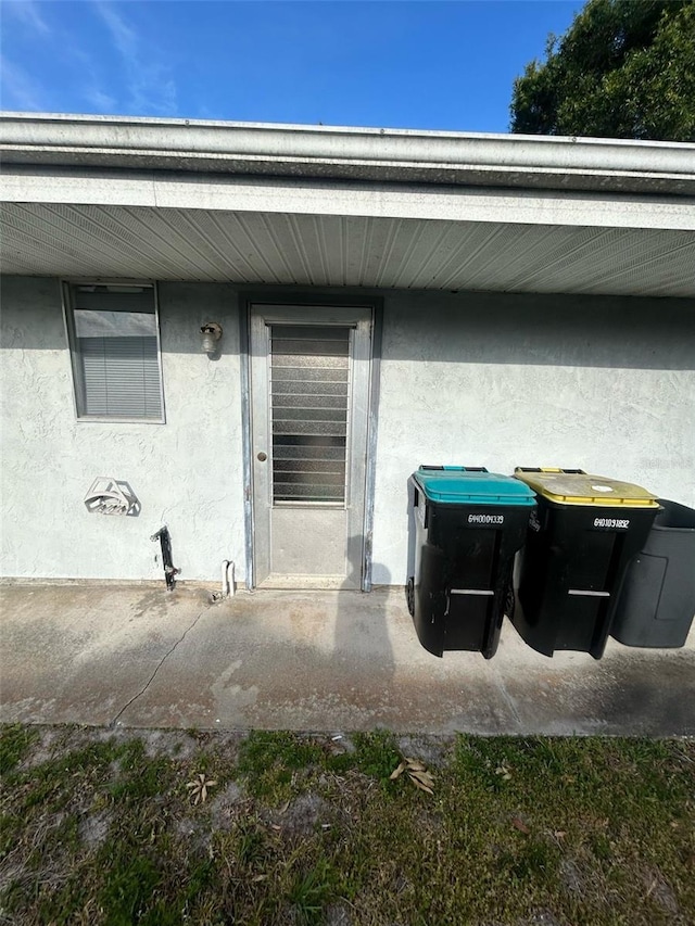 doorway to property featuring stucco siding