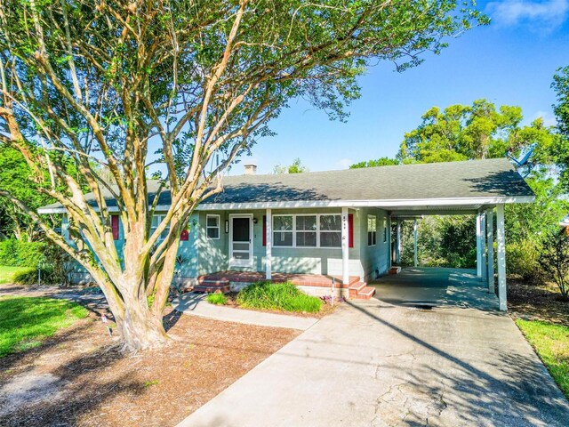 1371 Sheridan St SW, Winter Haven, FL 33880 - view of front of property with a shingled roof, an attached carport, a chimney, and concrete driveway