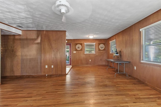 1371 Sheridan St SW, Winter Haven, FL 33880 - interior space featuring wooden walls, ceiling fan, hardwood / wood-style flooring, and visible vents
