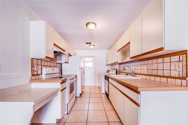 151 Winter Ridge Dr Unit 151, Winter Haven, FL 33881 - kitchen featuring decorative backsplash, a sink, light countertops, white electric range oven, and washer and dryer