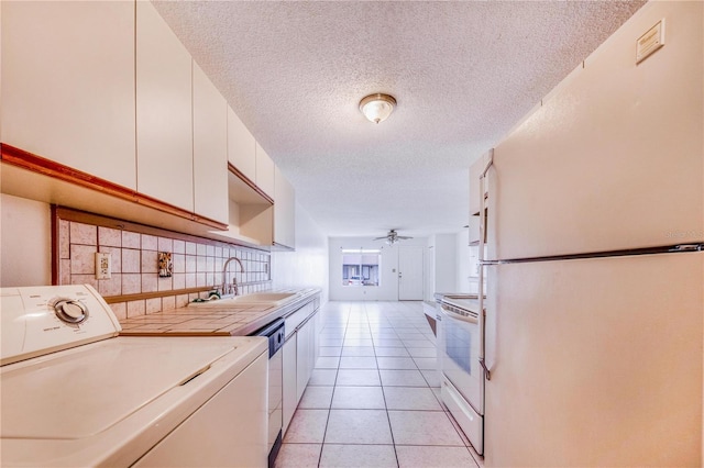151 Winter Ridge Dr Unit 151, Winter Haven, FL 33881 - clothes washing area featuring laundry area, washer / dryer, a textured ceiling, a sink, and light tile patterned floors