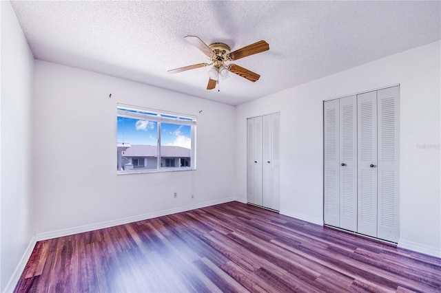 151 Winter Ridge Dr Unit 151, Winter Haven, FL 33881 - unfurnished bedroom with wood finished floors, two closets, baseboards, ceiling fan, and a textured ceiling