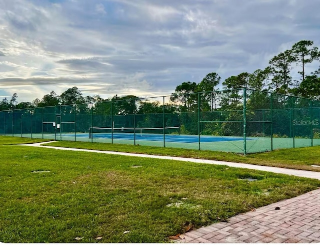 view of sport court with fence and a yard