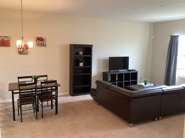 living area with baseboards, light colored carpet, and a chandelier