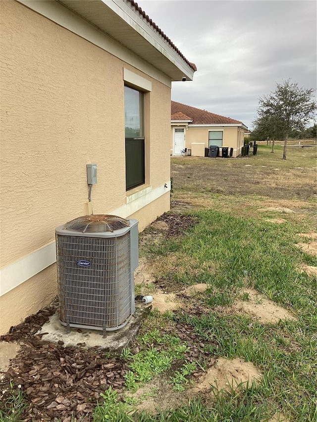exterior details featuring central air condition unit and stucco siding
