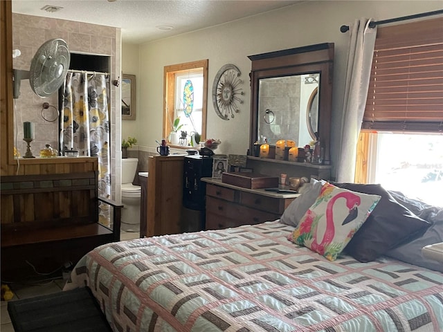 124 Palm Pl, Haines City, FL 33844 - bedroom featuring multiple windows, a textured ceiling, and ensuite bath