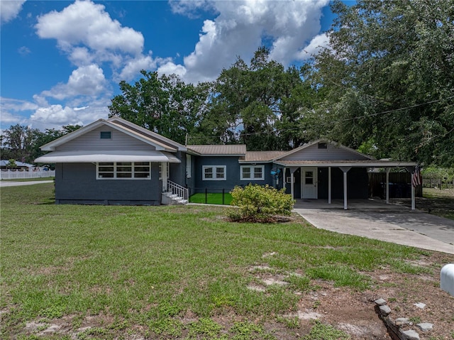 803 7th St NE, Fort Meade, FL 33841 - view of front facade featuring driveway, an attached carport, and metal roof