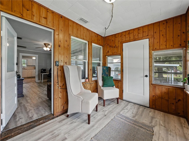 803 7th St NE, Fort Meade, FL 33841 - living area featuring wood walls, a ceiling fan, and light wood-style floors
