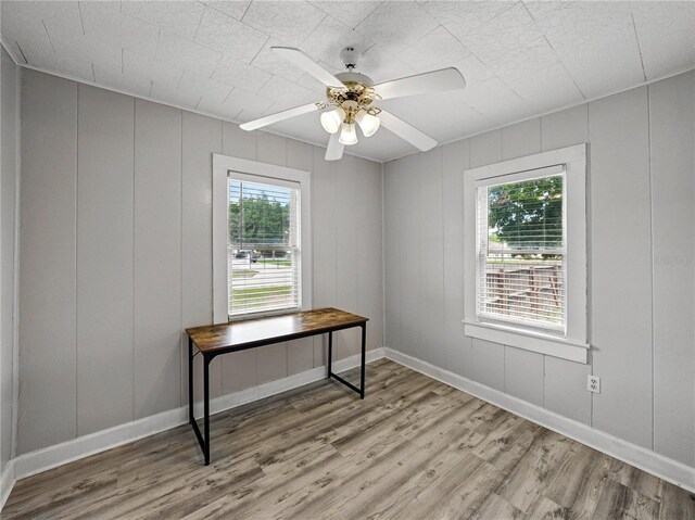 803 7th St NE, Fort Meade, FL 33841 - unfurnished office with wood finished floors, a decorative wall, a ceiling fan, and baseboards