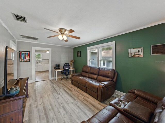 803 7th St NE, Fort Meade, FL 33841 - living room featuring a desk, ornamental molding, a ceiling fan, light wood finished floors, and baseboards