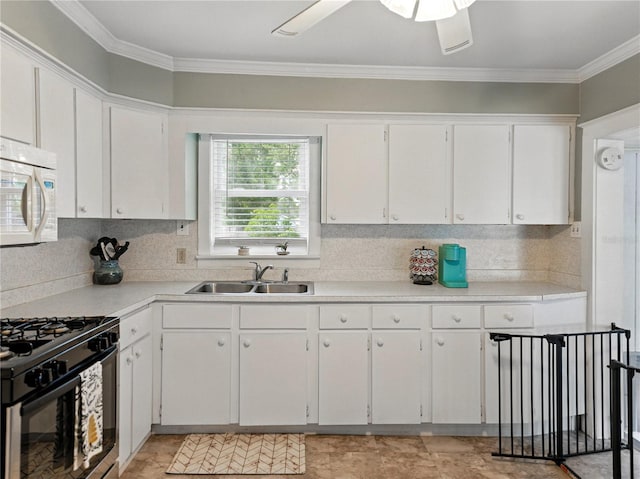 803 7th St NE, Fort Meade, FL 33841 - kitchen featuring white microwave, a sink, black gas stove, white cabinets, and crown molding