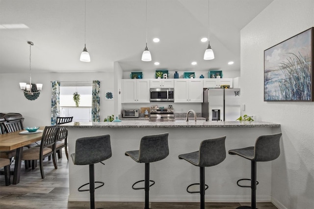 kitchen featuring white cabinets, decorative light fixtures, appliances with stainless steel finishes, and a toaster
