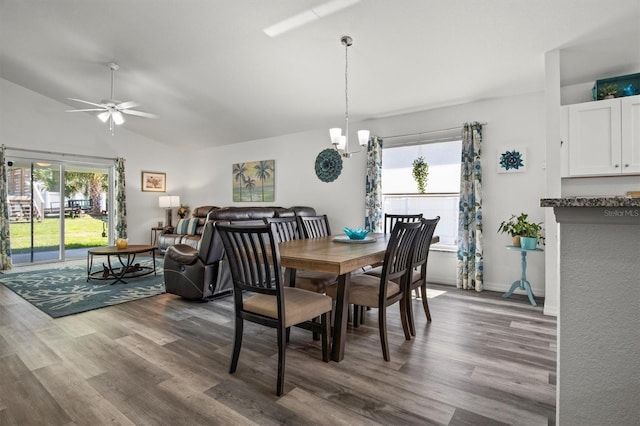 dining room with lofted ceiling, plenty of natural light, wood finished floors, and ceiling fan with notable chandelier